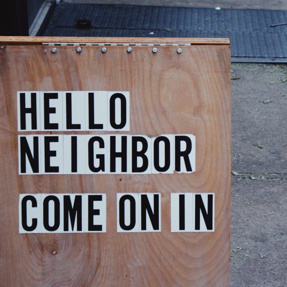 brown wooden board with hello neighbor come on in signage